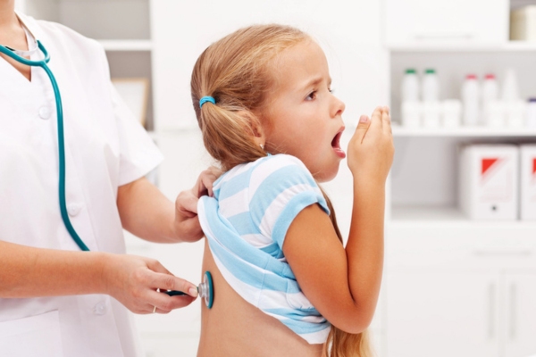kid coughing getting checked at the doctor depicting respiratory issues
