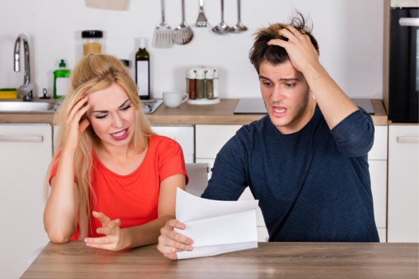 couple looking shocked and problematic due to high energy bill depicting window air conditioner inefficiency