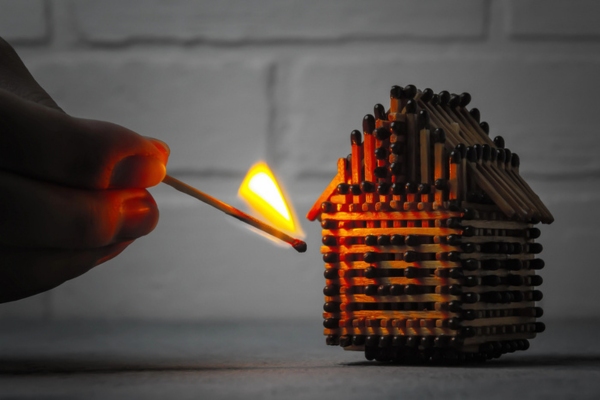 lighting up house made of matchsticks depicting fire hazards