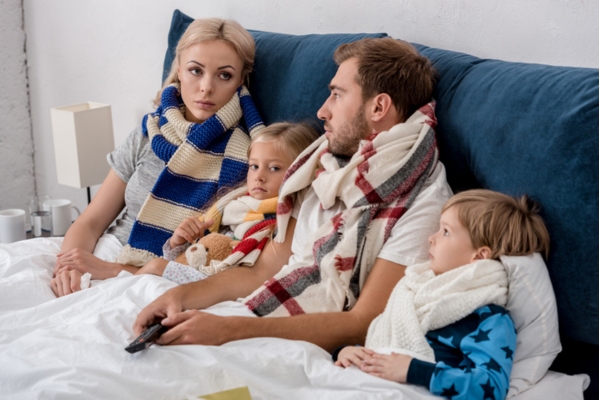 family lounging in the bedroom wearing scarves due to overheating and malfunctioning furnace