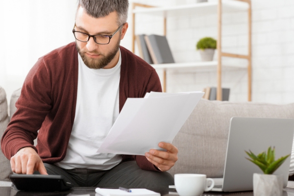 man wearing glasses assessing home heating expenses