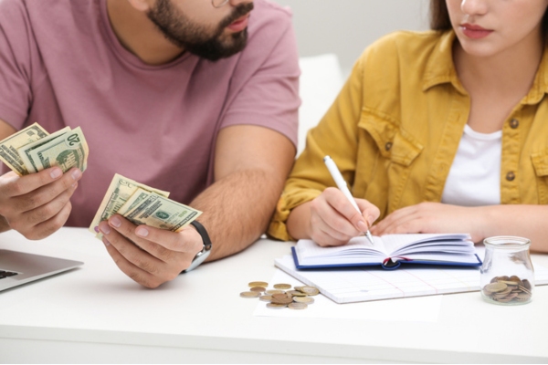 couple counting money while budgeting depicting fuel savings