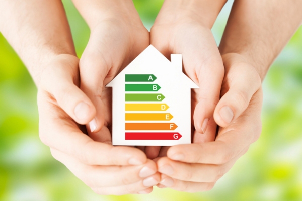 two sets of hand holding a miniature house with energy efficiency meter